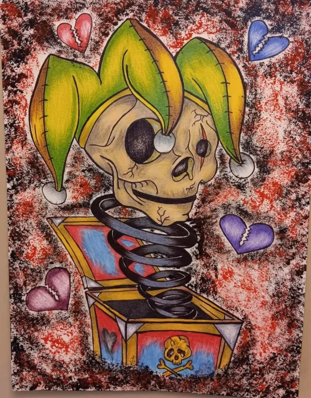 A jester skull with a green and yellow hat emerges from a spring-loaded box, surrounded by broken hearts against a red and white textured background.